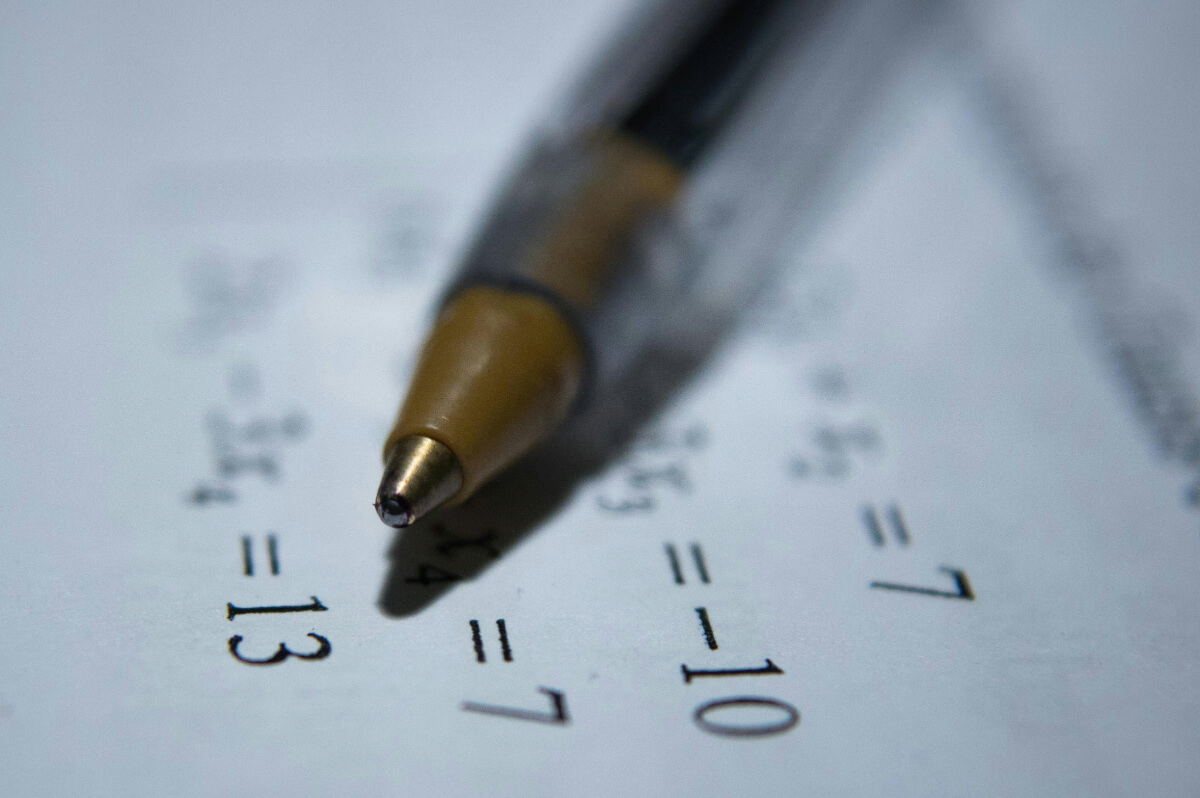 calculations using mathematical formulas with pen and paper